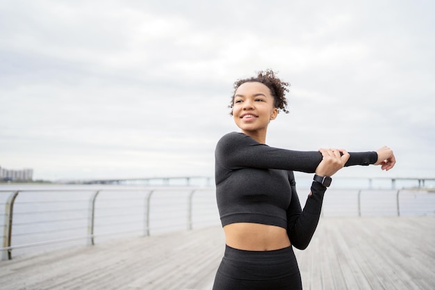 Een vrouwelijke atleet die actieve cardiofitnessoefeningen doet, gebruikt een fitnesshorloge en een tracker om haar hartslag te meten