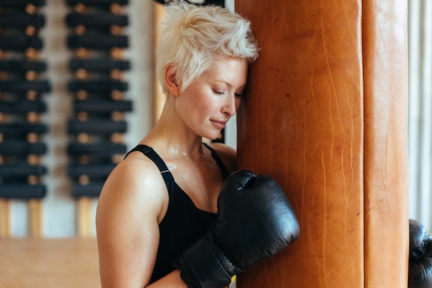 Een vrouwelijke bokser en een bokszak het concept van een sterke vrouw