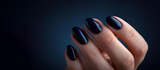 Een vrouwelijke hand met een prachtige donkerblauwe anecure Reclame voor manicure