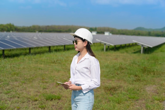 Een vrouwelijke ingenieur die een helm draagt in een fotovoltaïsche cel of zonnepanelenveld
