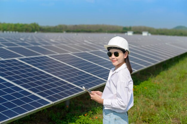 Een vrouwelijke ingenieur die een helm draagt in een fotovoltaïsche cel of zonnepanelenveld