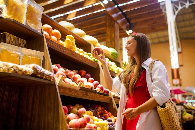 Een vrouwelijke klant die fruit kiest in een groentewinkel