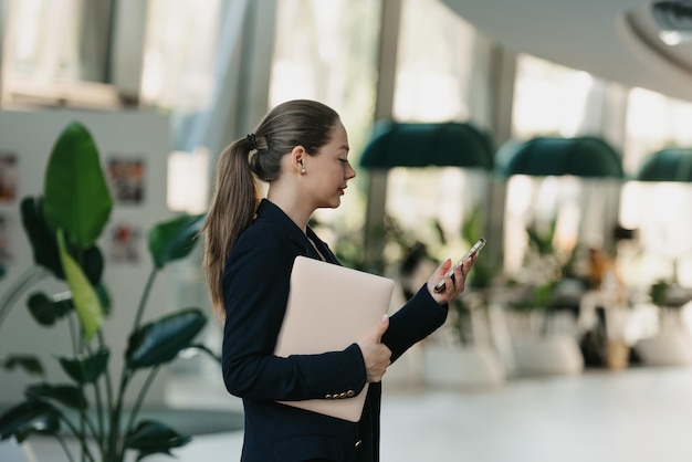 Een vrouwelijke makelaar in een blazer werkt aan de tafel in de moderne lobby