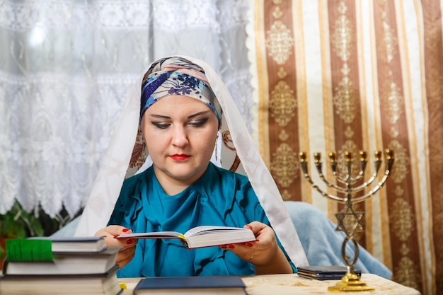 Een vrouwelijke rabbijn van een Reform Judaism-gemeenschap op Kisui Rosh bidt aan tafel voor een siddur Horizontale foto