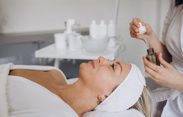 Een vrouwelijke schoonheidsspecialist houdt een pipet met etherische olie vast voor aromatherapie en massage aan de patiënt aromatherapieCloseup