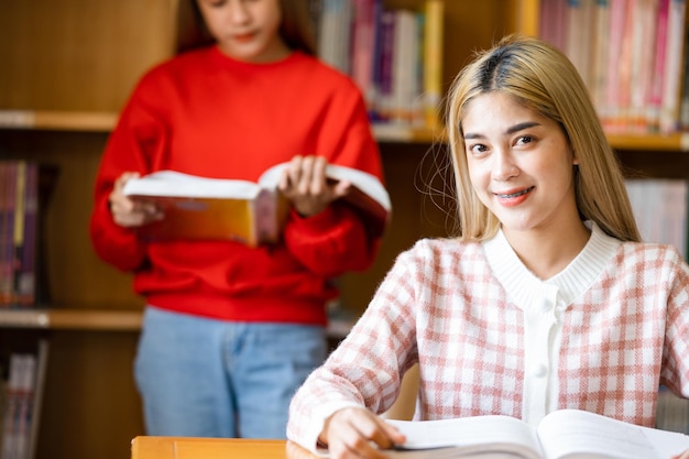 Een vrouwelijke student leest een boek in de universiteitsbibliotheek