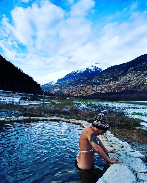 Een vrouwelijke toerist geniet van een natuurlijke spa in de schilderachtige plaats van de winterbergen