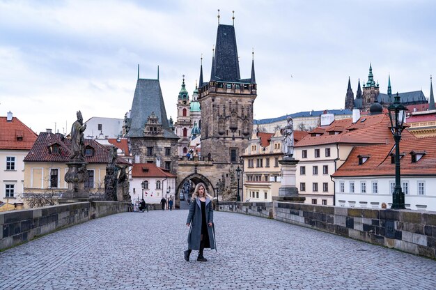 Een vrouwelijke toerist in een overjas reist door Praag. Een mooie toeristische plek. Kasteel van Praag