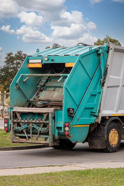 Foto een vuilniswagen haalt afval op in een woonwijk. gescheiden inzameling en verwijdering van afval. vuilniswagen.