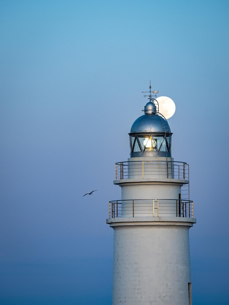 Foto een vuurtoren met een volle maan aan de hemel