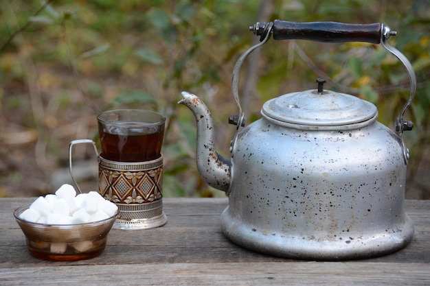 Een waterkoker en een kopje koffie op een houten tafel