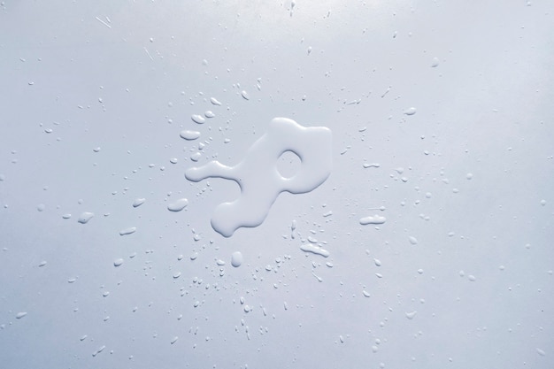 Een waterplons verlicht op het witte tafeloppervlak, abstracte regendruppels