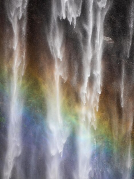 Foto een waterval met een regenboog op de achtergrond