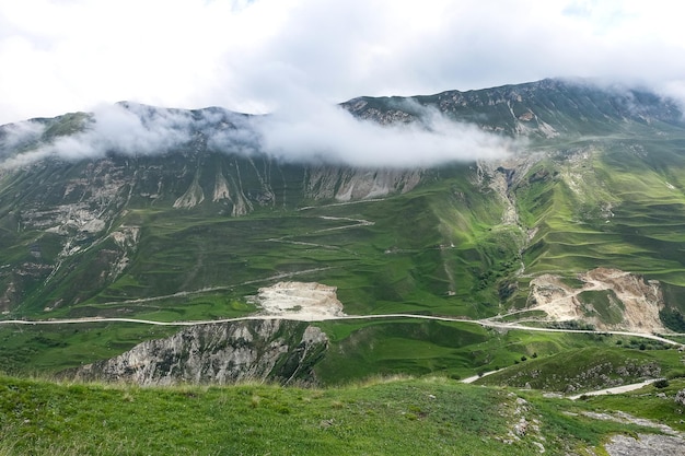 Een weg in de bergen van Dagestan met grote bergen op de achtergrond en wolken Rusland