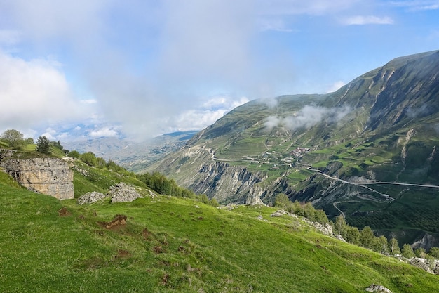 Een weg in de bergen van Dagestan met grote bergen op de achtergrond en wolken Rusland