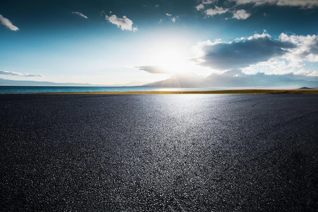 Een weg met een blauwe lucht en de zon erop