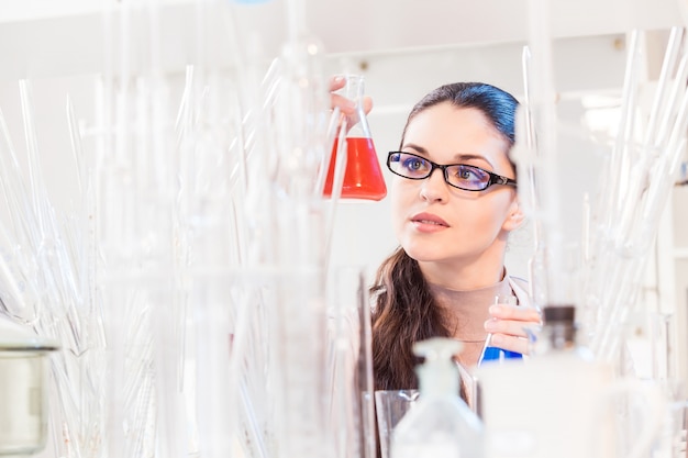 Een wetenschapper in een laboratorium dat de vloeistof in de beker bestudeert