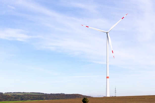 Foto een windmolen op een veld met een bewolkte hemel