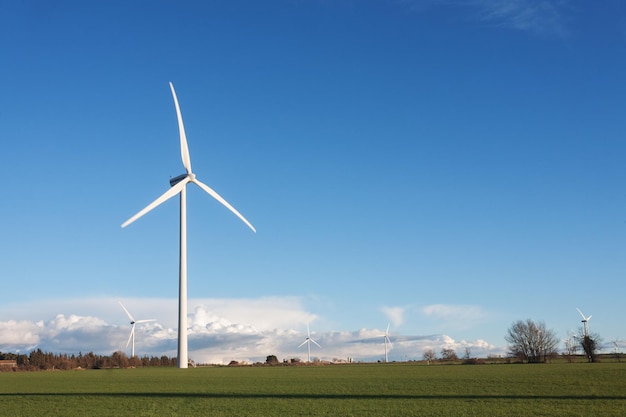 Foto een windturbine staat in een veld met een heldere blauwe lucht