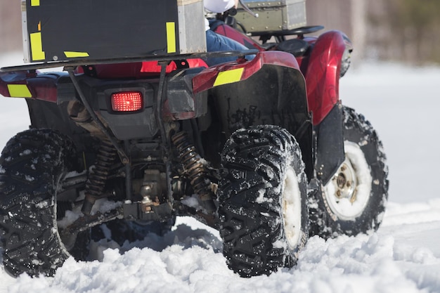 Een winterbos overdag een vrouw die op een sneeuwscooter rijdt overdag achteraanzicht