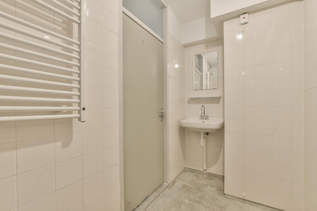 Een witte badkamer voorzien van een douche en een wastafel