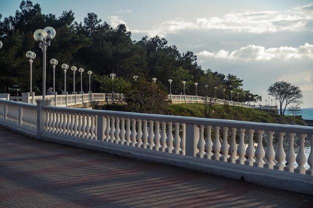 Een witte balustrade werpt prachtige schaduwen bij zonsondergang op de dijk