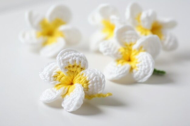 Een witte bloem met gele bloemblaadjes staat op een witte tafel.