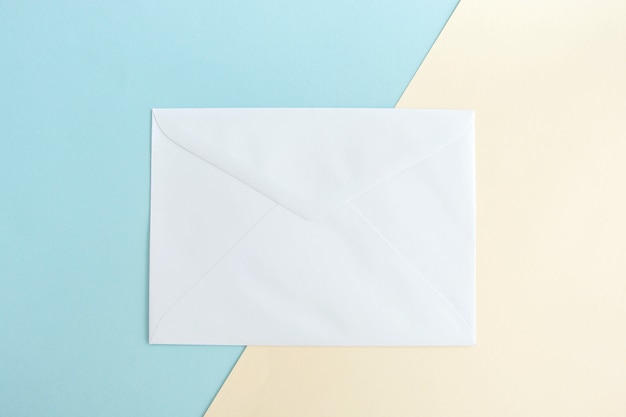 Een witte envelop op een pastel achtergrond.