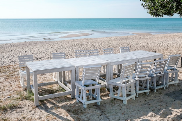 Een witte houten tafel en stoelen op het strand