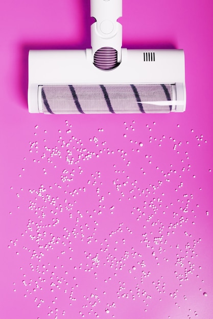 Een witte stofzuigerborstel op een roze achtergrond. Het concept van schoonmaken of stofzuigen.