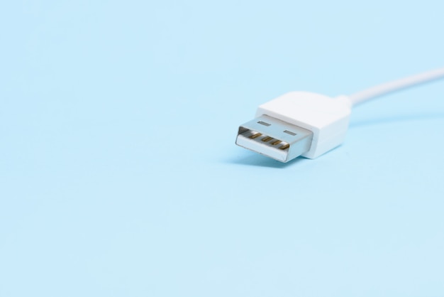 Een witte USB-kabel stekker geïsoleerd op lichte blauwe achtergrond.