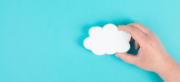 Een witte wolk in de hand houden, lege kopieerruimte voor tekst, blauwe achtergrond, communicatie