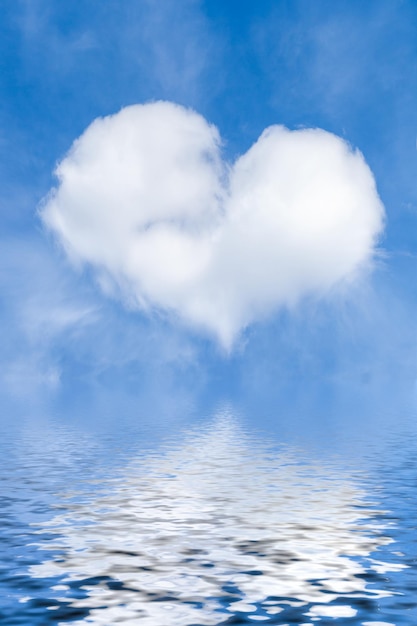 Een witte wolk in de vorm van een hart op een blauwe lucht en met een weerspiegeling in het water