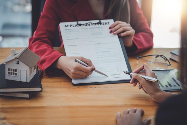 Een zakelijk contract ondertekenen Een groep zakenmensen die een investering ontmoeten en ondertekenen voor het kopen en verkopen van een huis en een onroerendgoedovereenkomst juridisch contractondertekeningsconcept