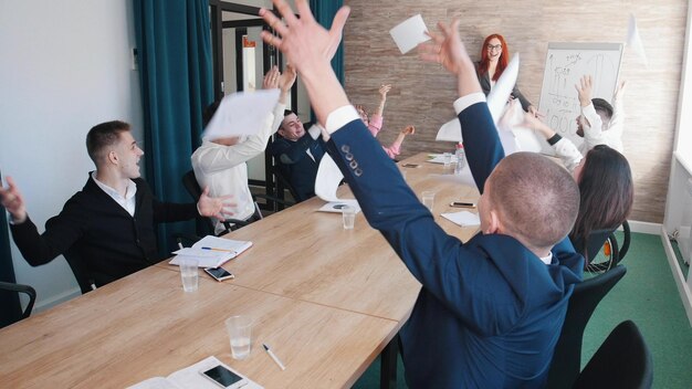 Een zakelijke conferentie op kantoor Mensen gooien papieren in de lucht