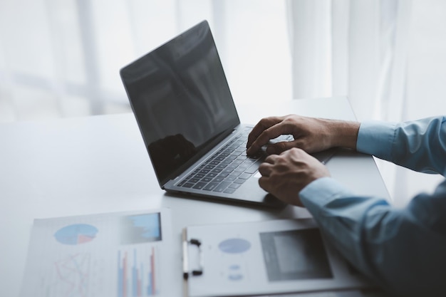 Een zakenman controleert de financiële documenten van het bedrijf en gebruikt een laptop om met de financieel directeur te praten via een berichtenprogramma Concept financieel beheer van het bedrijf