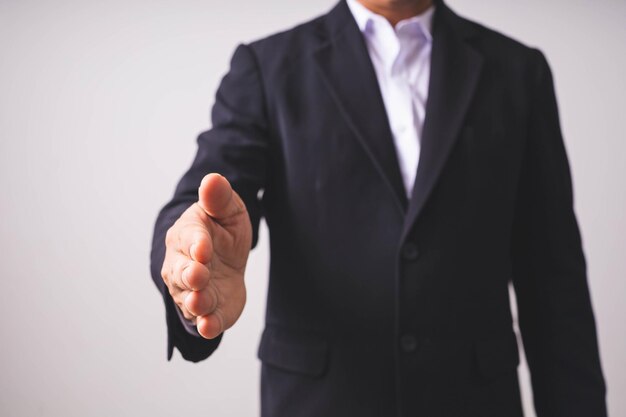 Foto een zakenman in een zwart pak staat en heft zijn handen op.