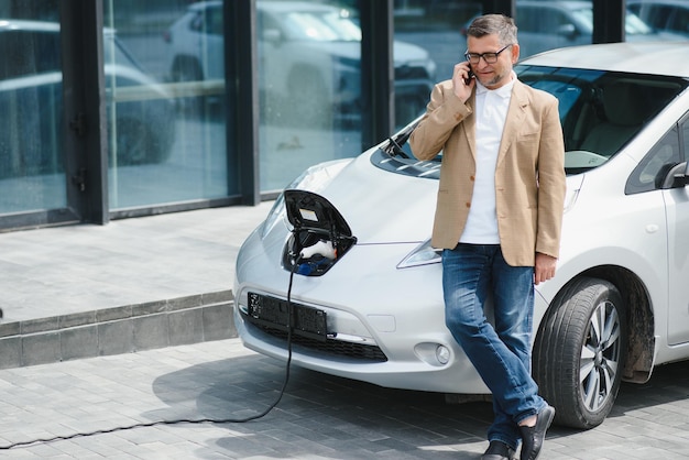 Een zakenman laadt een elektrische auto op