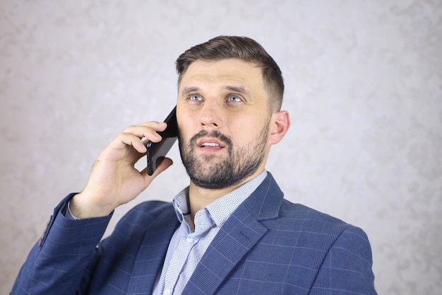 Een zakenman met een telefoon in zijn hand is aan het onderhandelen