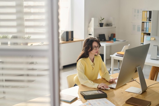 Een zakenvrouw die op haar werkplaats aan een computer werkt