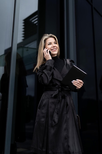 Een zakenvrouw houdt een telefoon in haar hand en spreekt met een partner via een mobiele verbinding