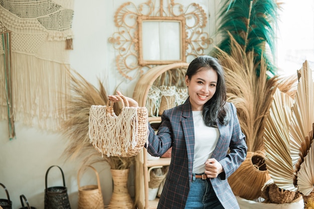 Een zakenvrouw in een blazer draagt een geweven tas in een ambachtswinkel