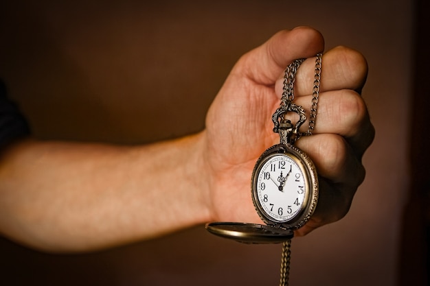 Foto een zakhorloge in de handen van een man