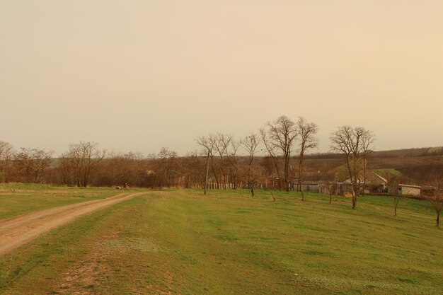 Een zandweg leidt naar een boerderij met een zandweg op de achtergrond.