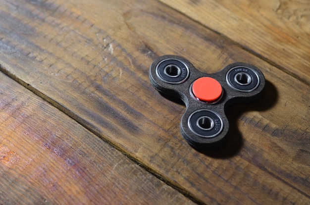 Een zeldzame handgemaakte houten fidget-spinner ligt op een bruine houten ondergrond