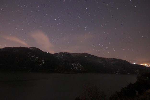 Een zicht op de sterren van de Melkweg met een bergtop op de voorgrond Perseïden meteorenregen