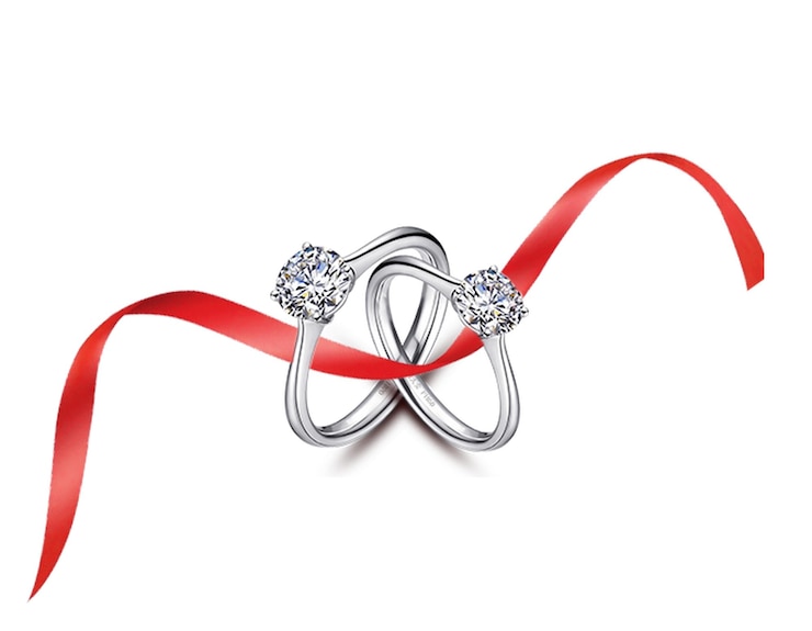 Foto een zilveren ring met diamanten erop is vastgebonden aan een rood lint