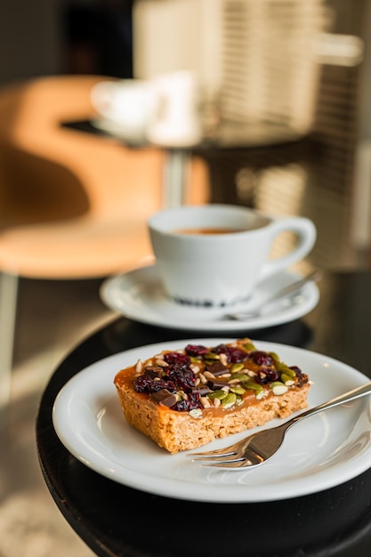 Foto een zoet dessert met karamelle cranberries en zaden en een kop zwarte koffie