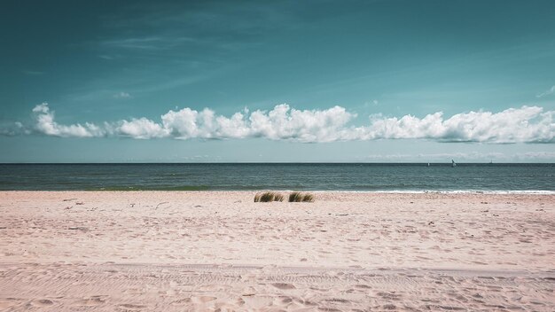 Foto een zomervakantiestrand met een blauwe lucht en wit zand