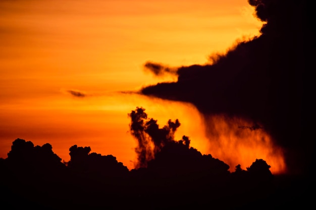 Een zonsondergang met een wolkje aan de lucht